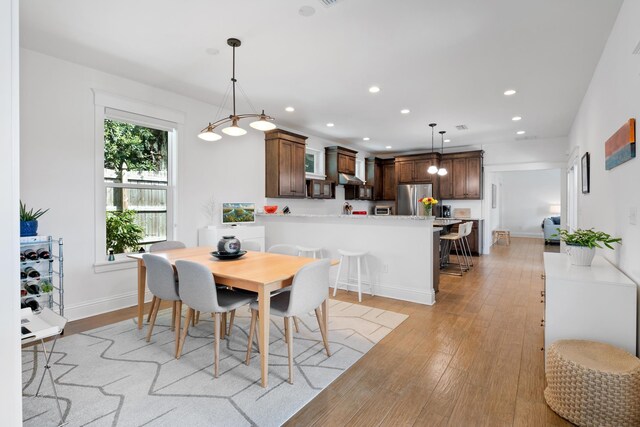 foyer entrance featuring visible vents, baseboards, stairs, light wood-type flooring, and an inviting chandelier