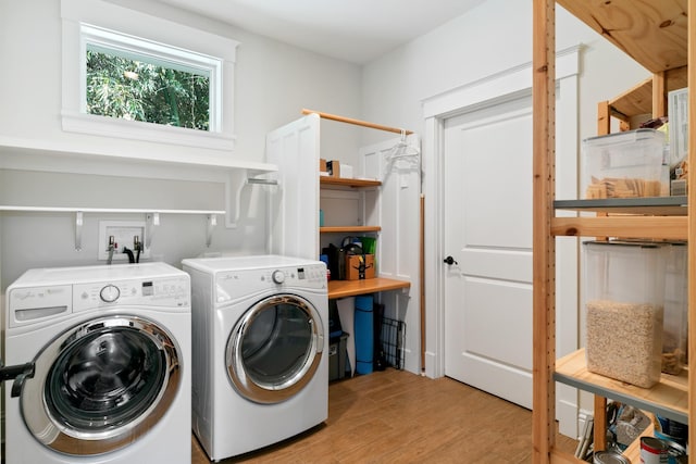 laundry area featuring laundry area, separate washer and dryer, and light wood-style flooring