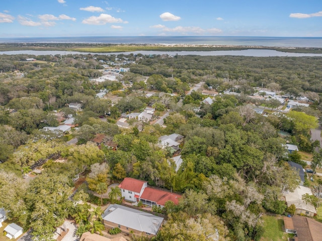 drone / aerial view with a forest view and a water view