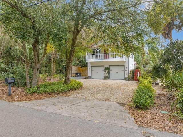 view of front of home with concrete driveway, fence, a balcony, and an attached garage