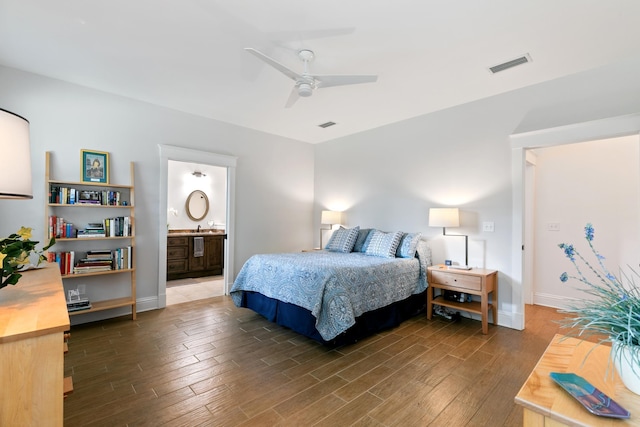 bedroom featuring ensuite bath, dark wood-style floors, baseboards, and visible vents