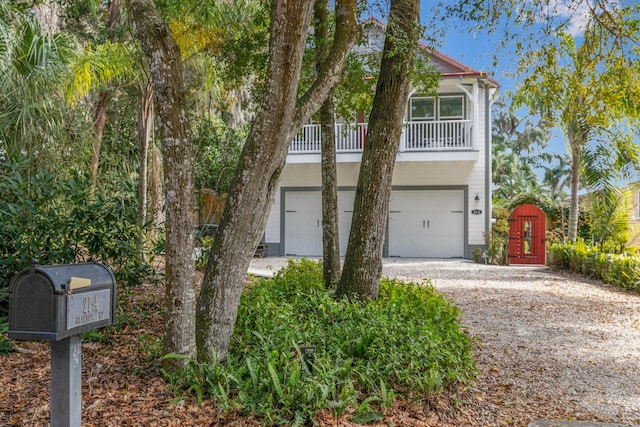 beach home featuring an attached garage and gravel driveway