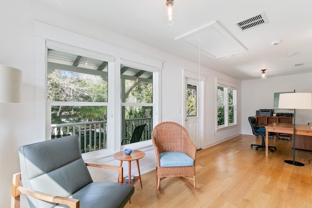 office space featuring visible vents, light wood-style flooring, attic access, and baseboards