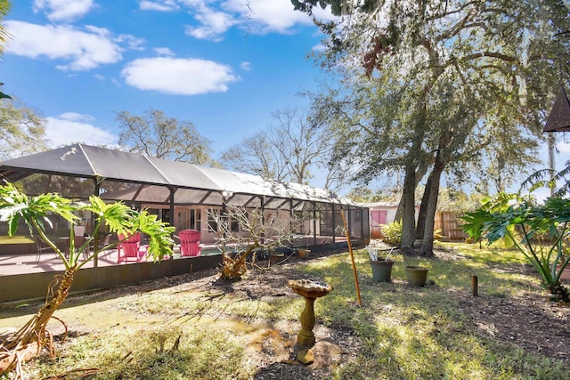 view of yard with glass enclosure, fence, and a pool