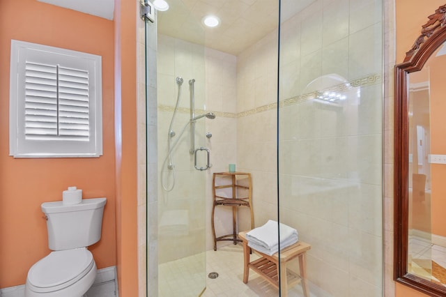 bathroom with a stall shower, baseboards, and toilet