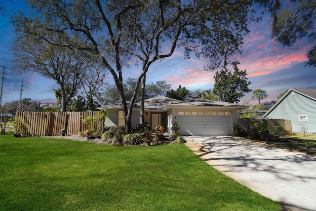 view of front of house with driveway, an attached garage, fence, and a front yard