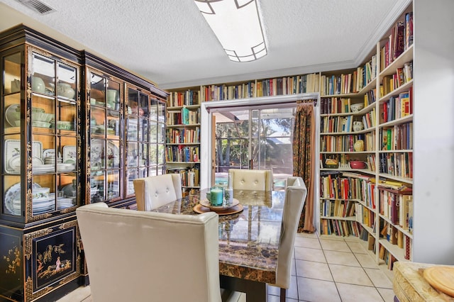 dining area featuring tile patterned flooring, visible vents, and a textured ceiling