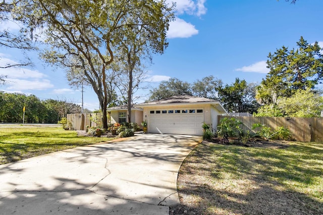 view of front of home with a garage, concrete driveway, fence, a front lawn, and stucco siding