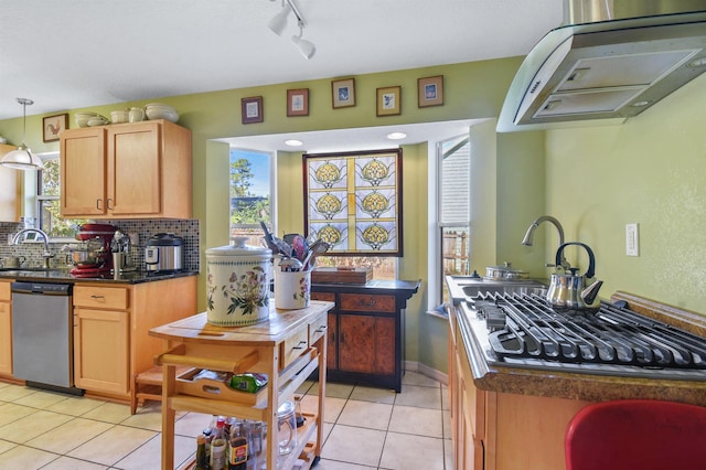 kitchen featuring tasteful backsplash, dark countertops, stainless steel dishwasher, and light tile patterned floors