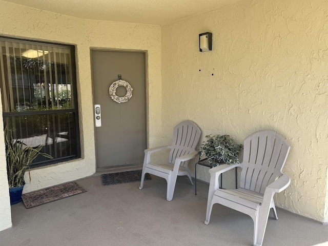 entrance to property featuring stucco siding and a patio