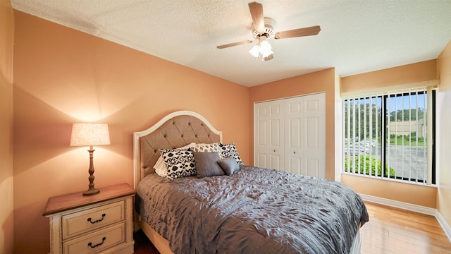 bedroom featuring ceiling fan, a closet, light hardwood / wood-style floors, and a textured ceiling