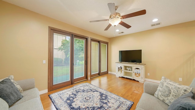 living room with ceiling fan and light wood-type flooring