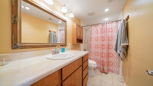 bathroom featuring tile patterned flooring, vanity, toilet, and a textured ceiling