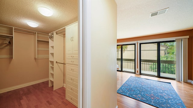 walk in closet with light hardwood / wood-style floors