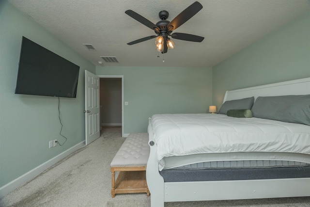 bedroom featuring a textured ceiling, a ceiling fan, visible vents, baseboards, and carpet