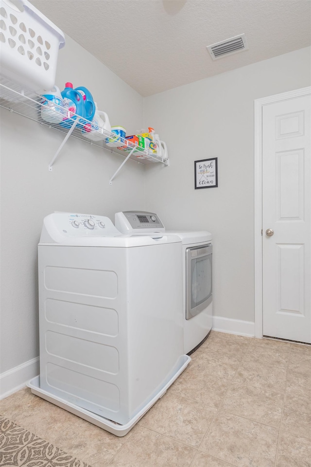 laundry room with laundry area, baseboards, visible vents, and washer and clothes dryer