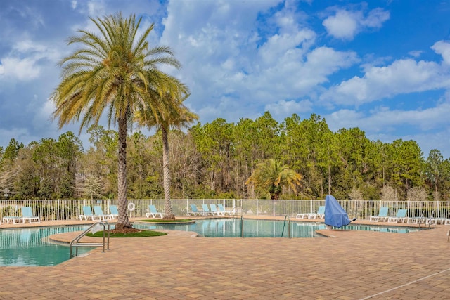 pool featuring fence and a patio