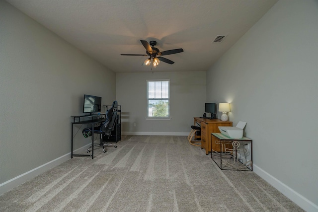 carpeted office space with a ceiling fan, visible vents, and baseboards