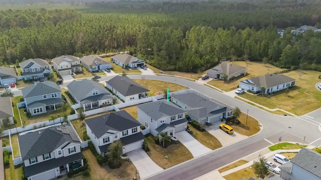 drone / aerial view with a residential view and a view of trees