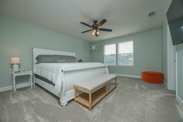 bedroom featuring a textured ceiling, a ceiling fan, visible vents, baseboards, and carpet