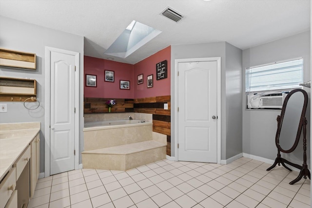 bathroom with a relaxing tiled tub, a textured ceiling, tile patterned floors, and vanity