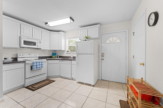 kitchen with white cabinetry, light tile patterned floors, and white appliances