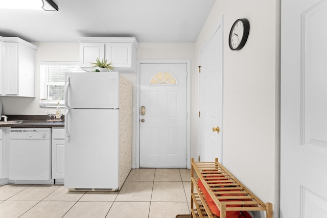 kitchen featuring light tile patterned floors, white appliances, and white cabinets