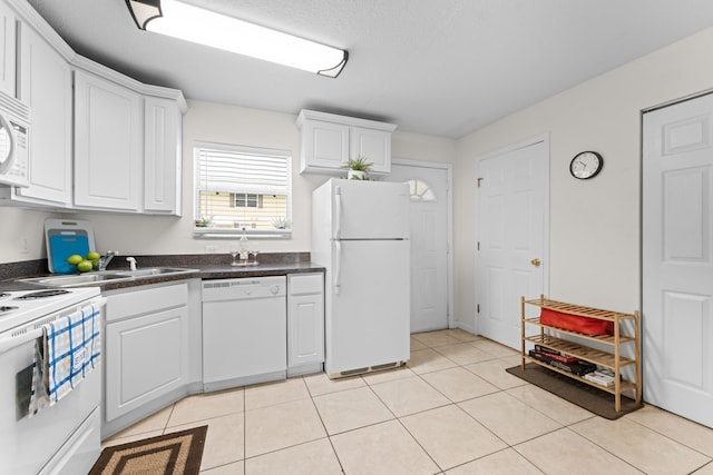 kitchen featuring light tile patterned floors, white appliances, sink, and white cabinets