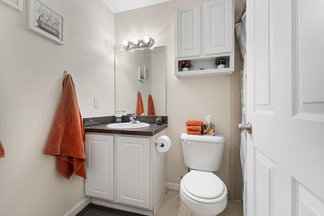 bathroom featuring vanity, tile patterned floors, and toilet