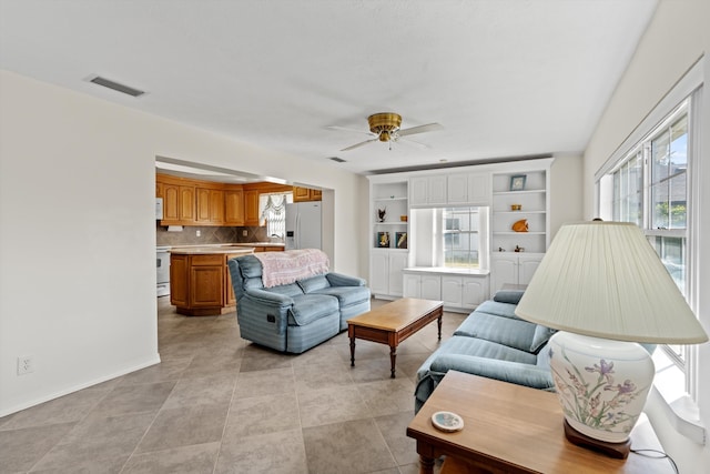 tiled living room with ceiling fan