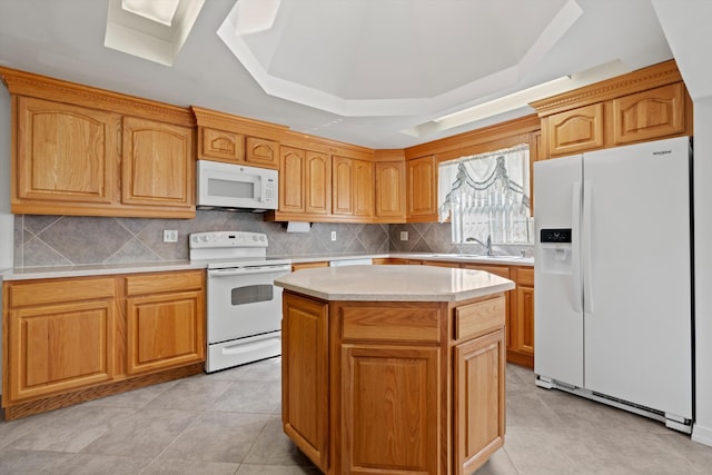 kitchen featuring a kitchen island, sink, decorative backsplash, a tray ceiling, and white appliances