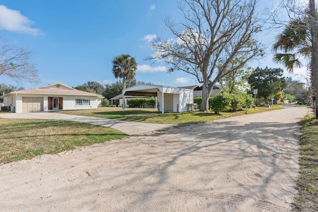 view of front of home featuring a carport, a garage, and a front lawn