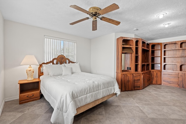 tiled bedroom featuring ceiling fan and a textured ceiling