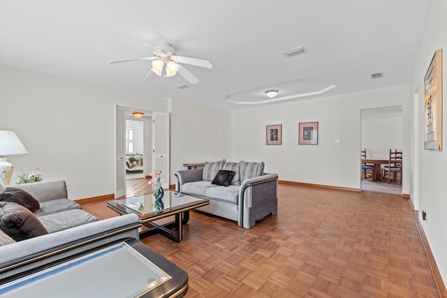 living room with ceiling fan and parquet flooring