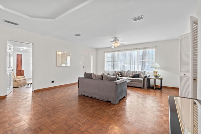 living room with ceiling fan and dark parquet floors