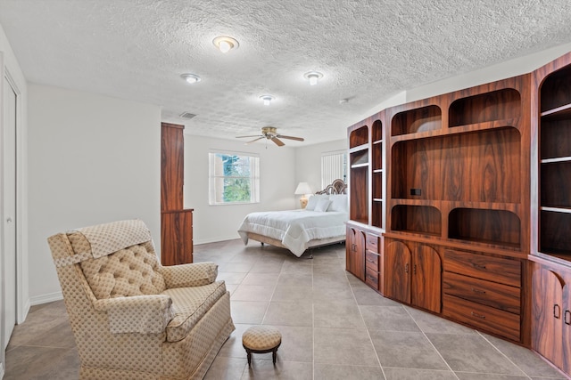 tiled bedroom featuring a textured ceiling and ceiling fan