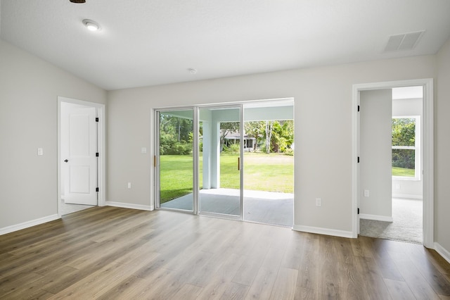 empty room with light wood-type flooring and lofted ceiling