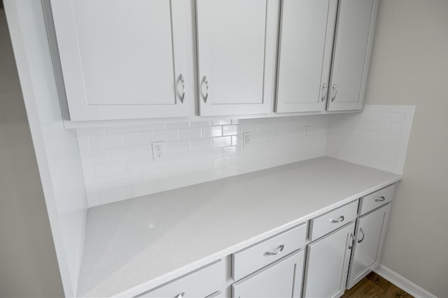 kitchen with backsplash, white cabinets, and dark hardwood / wood-style flooring