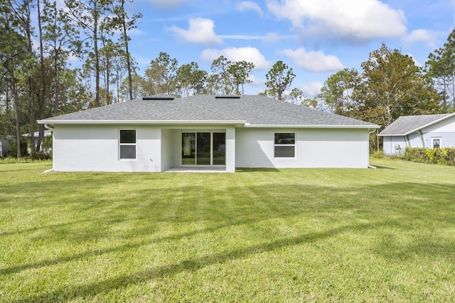 rear view of property with a lawn