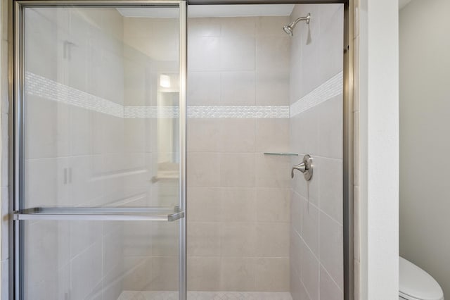 bathroom featuring walk in shower and toilet