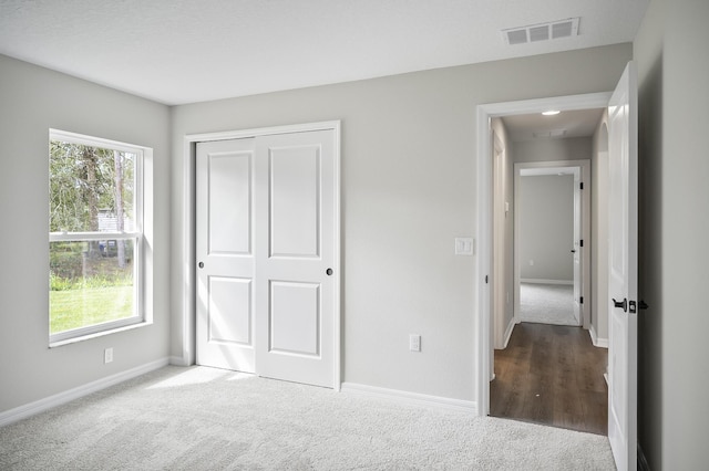 unfurnished bedroom with a closet and carpet floors