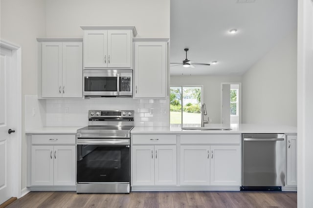 kitchen featuring stainless steel appliances, backsplash, white cabinetry, and sink