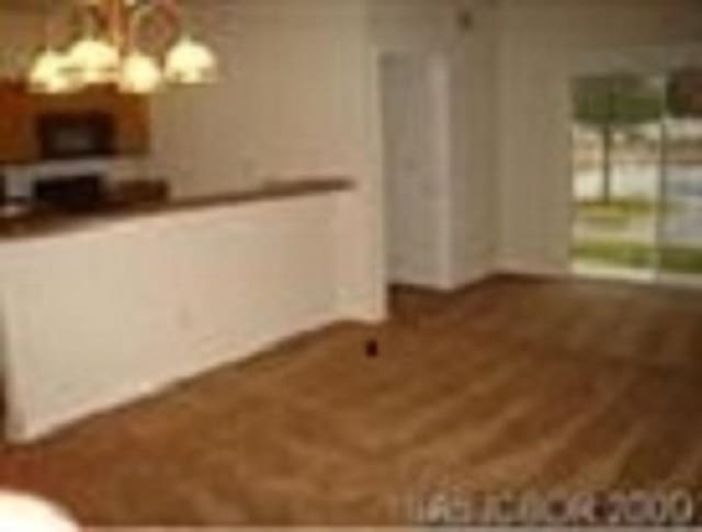 2550 Golden Lake Loop, Saint Augustine, FL 32084 - unfurnished living room featuring a chandelier and baseboards