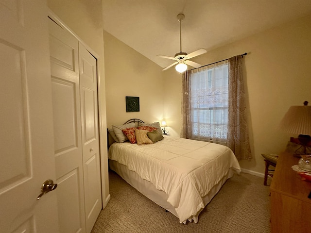 carpeted bedroom with a closet, ceiling fan, and lofted ceiling