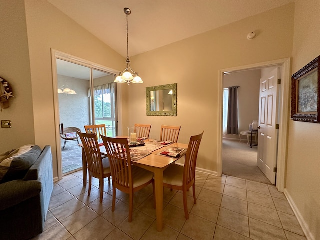 dining area with a chandelier, light tile patterned flooring, and vaulted ceiling