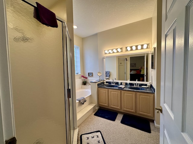 bathroom with vanity, a textured ceiling, and independent shower and bath