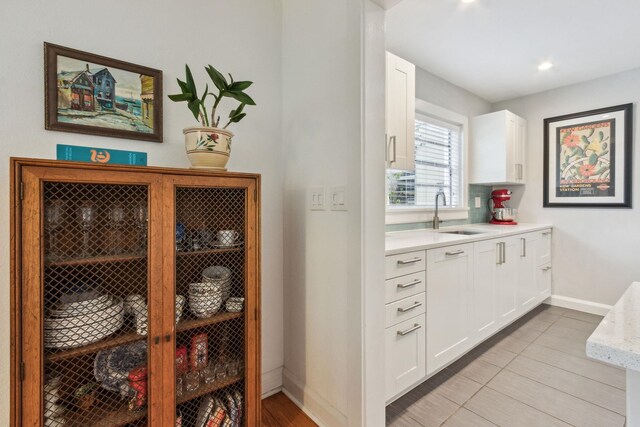 kitchen featuring white cabinetry, sink, and light tile patterned flooring