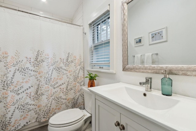 bathroom featuring curtained shower, vanity, and toilet