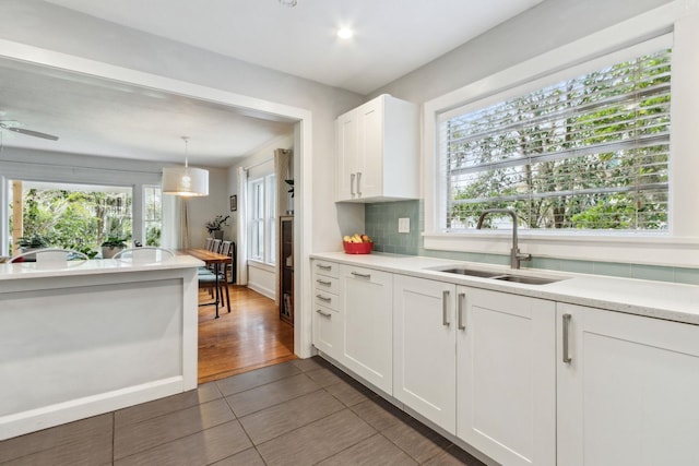 kitchen featuring white cabinetry, sink, ceiling fan, tasteful backsplash, and pendant lighting