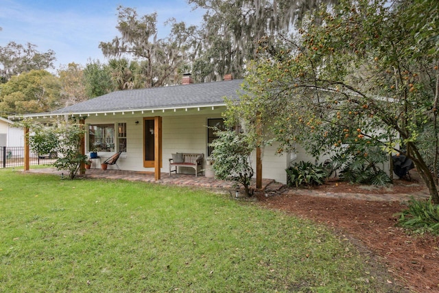 rear view of house featuring a porch and a yard